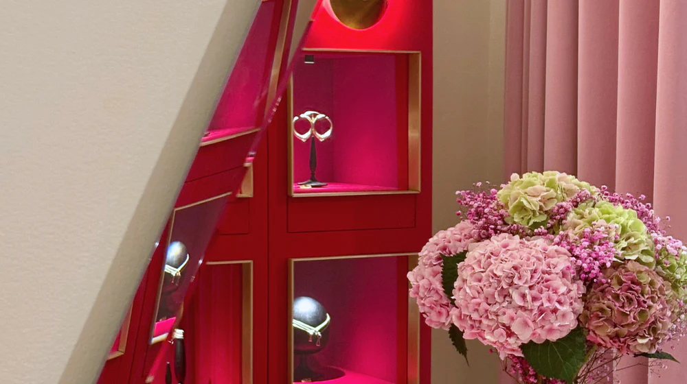 Boutique display featuring Nada Ghazal jewelry and a bucket of flowers